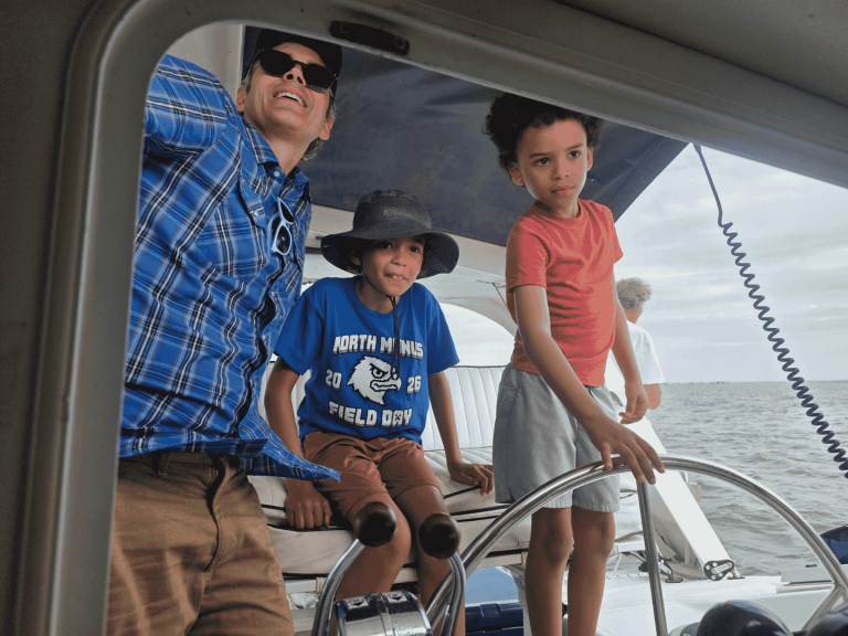 family on sailing cruise at the wheel with causeway watersports