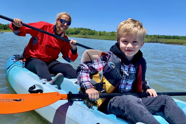 Adult and child sharing a kayak in the Outer Banks