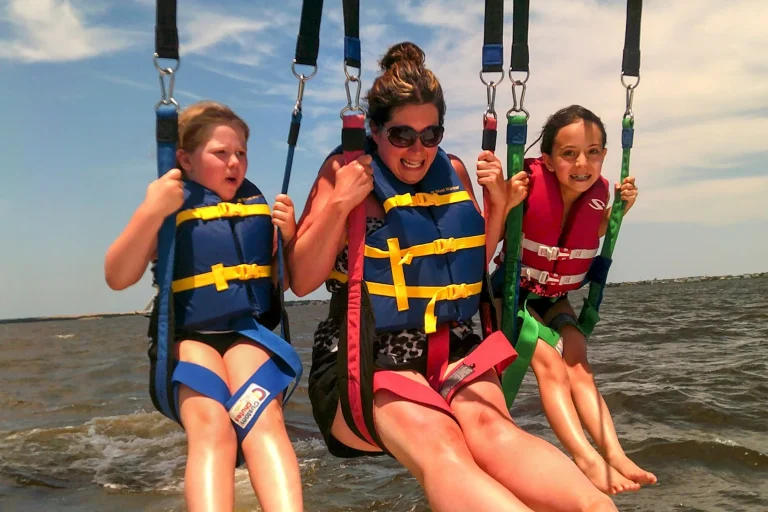 Three kids being dipped in the water on a parasailing flight over Roanoke Sound in Nags Head