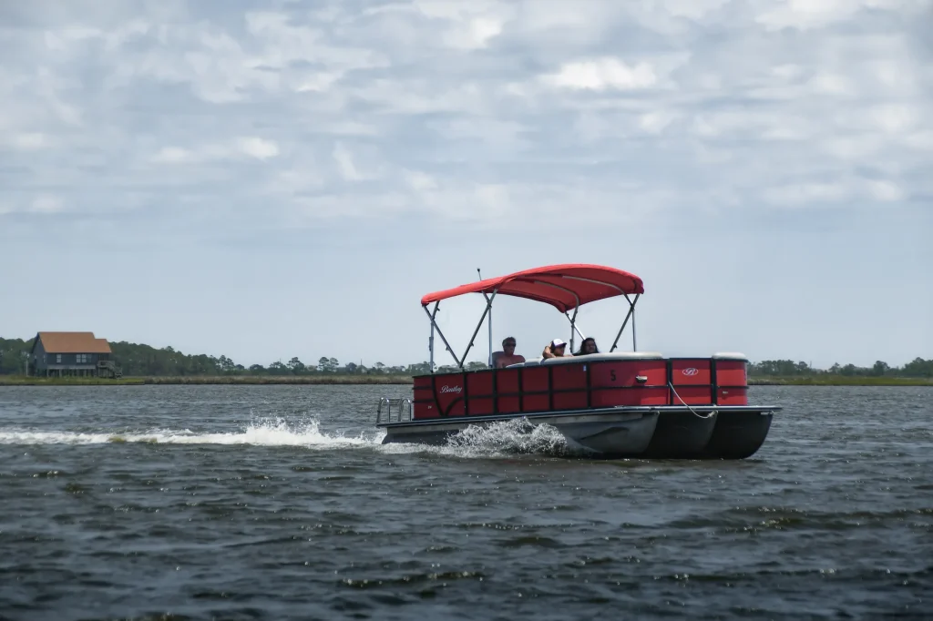 Group riding a red 16-person pontoon boat in Nags Head