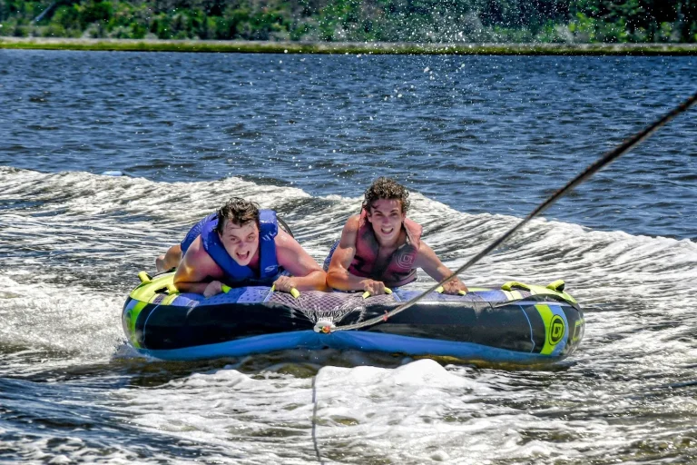 Two riders gripping the tube through the boat wake in Nags Head