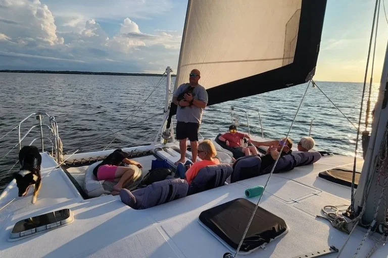 Guests and a dog on the bow of a catamaran cruise in the Outer Banks