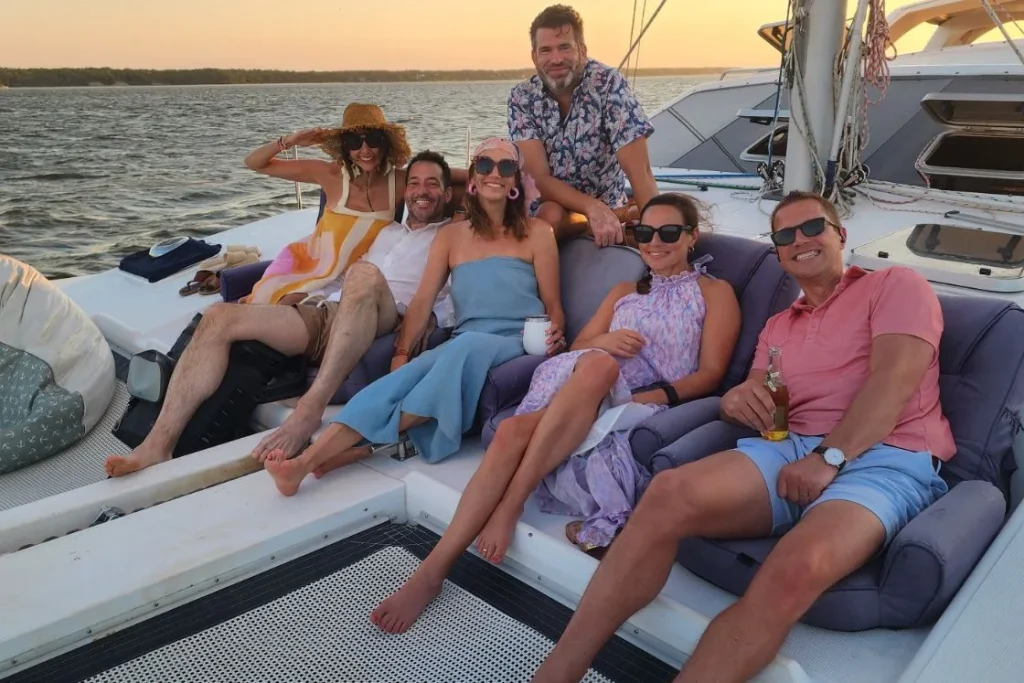 Group enjoying a golden-hour cruise aboard the sailing catamaran