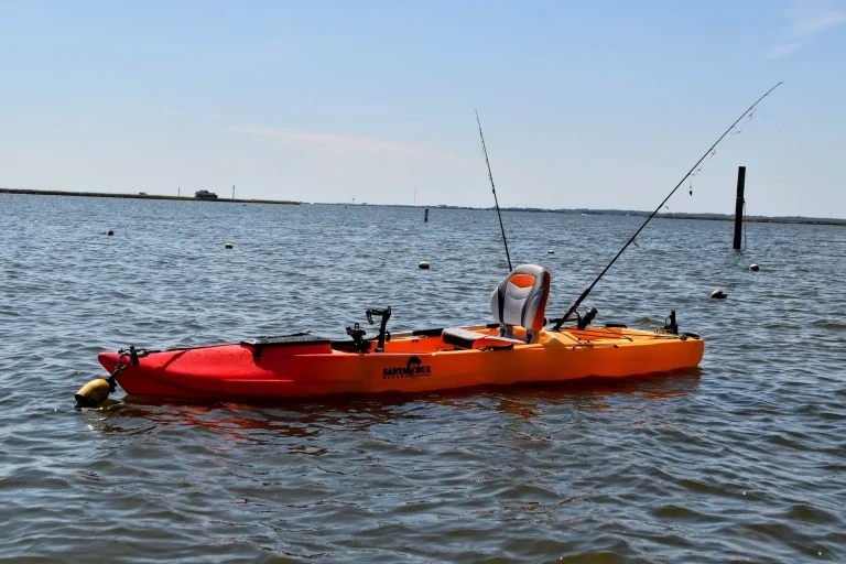 Fishing kayak rigged with rod holders on calm water