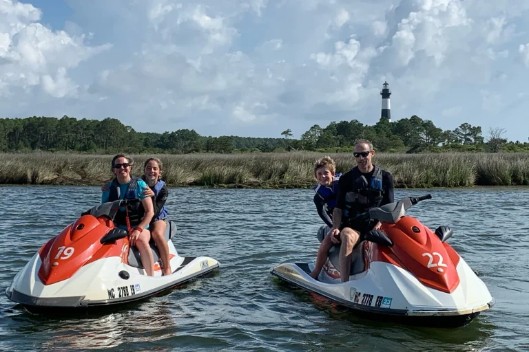 Jet skiers lined up with Bodie Island Lighthouse in the background