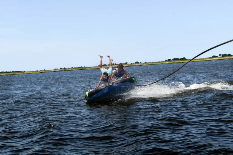 Towable tube kicking up spray behind the boat in the Outer Banks
