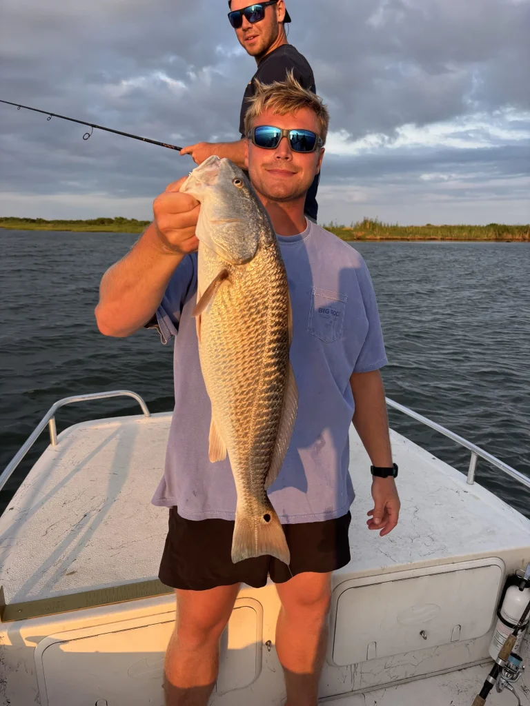 Angler holding a redfish caught from a Causeway Watersports skiff rental