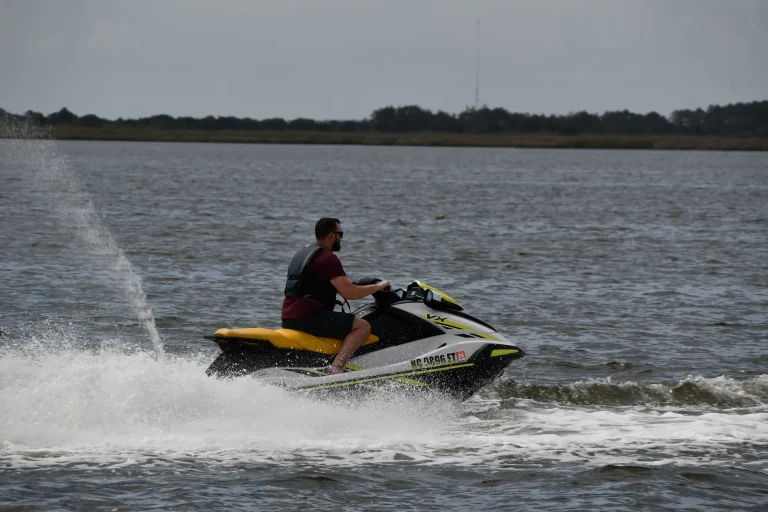 Jet ski rider carving a turn with spray on the Outer Banks sound