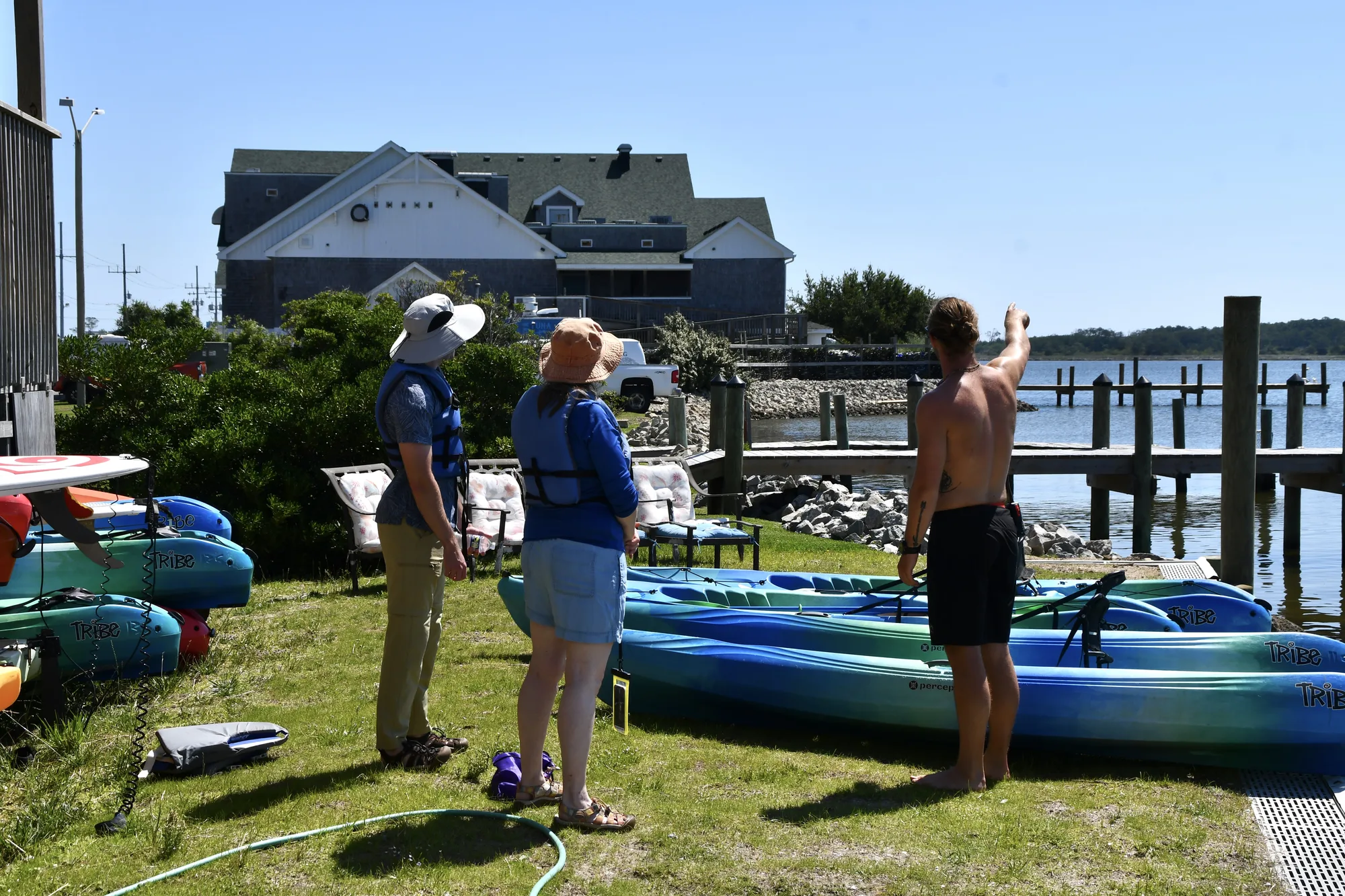 Rental kayaks staged on the lawn at the Causeway Watersports launch
