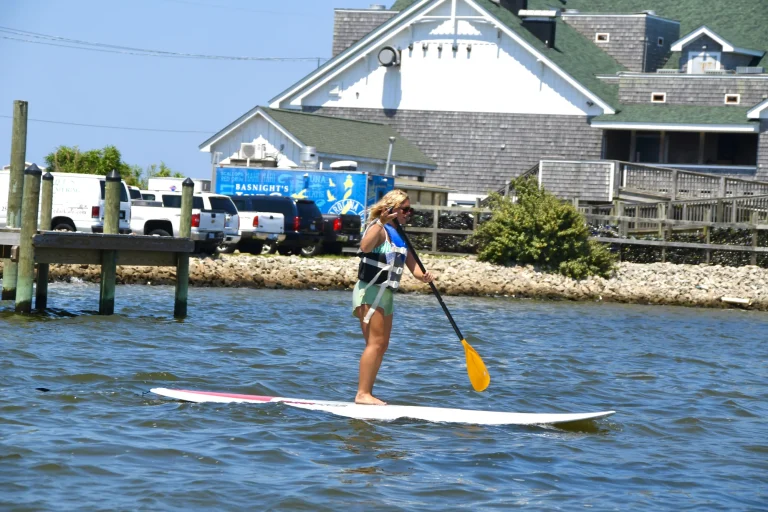 Paddleboarder gliding past the waterfront near the shop