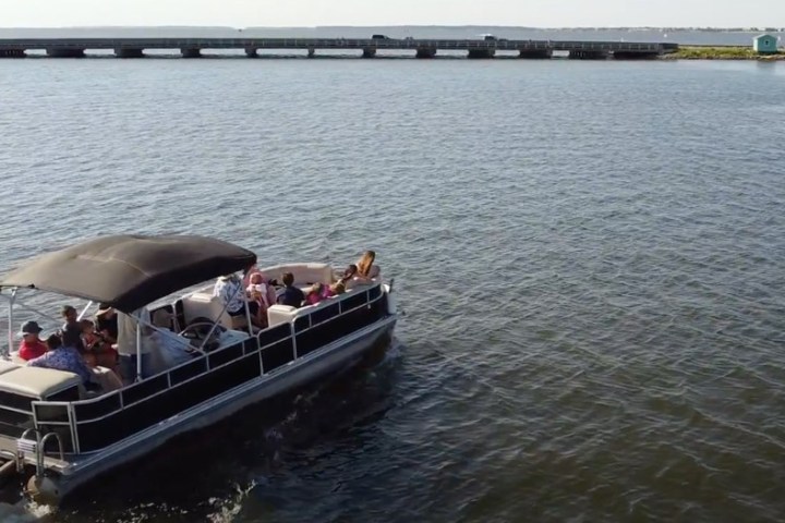 An overhead view of a family enjoying a cruise on a pontoon rental in Nags Head.