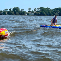 a man riding on the back of a boat in a body of water