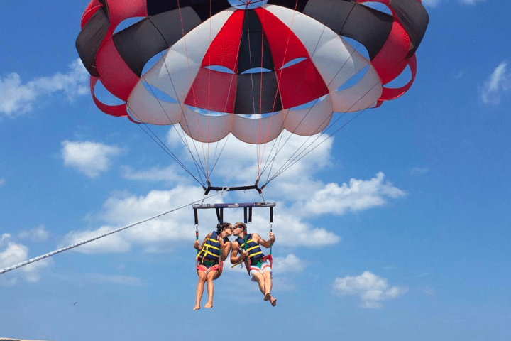 A couple kissing while parasailing in Nags Head NC.