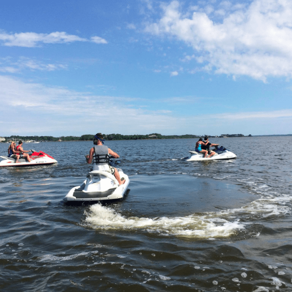 a group of people riding on the back of a boat in the water