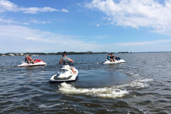 a group of people riding on the back of a boat in the water