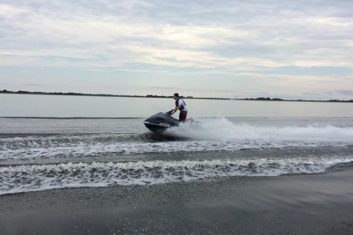 A man riding a jet ski on the open waters of Nags Head, While on Vacation in the OBX.