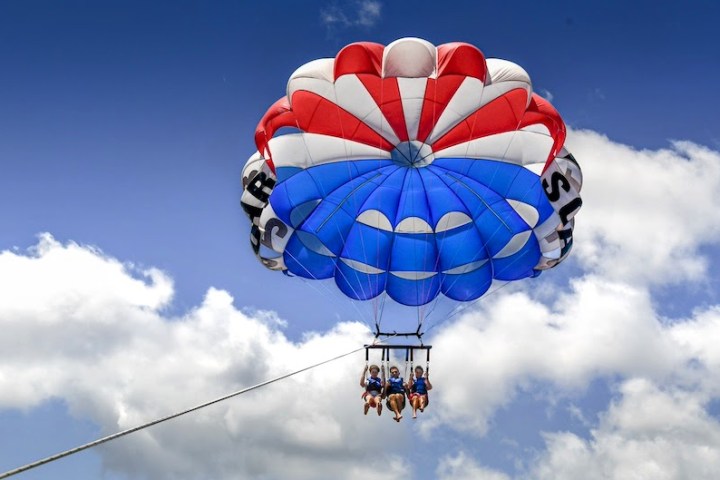 A family parasailing together in the clouds, while on their vacation in the Outer Banks NC.