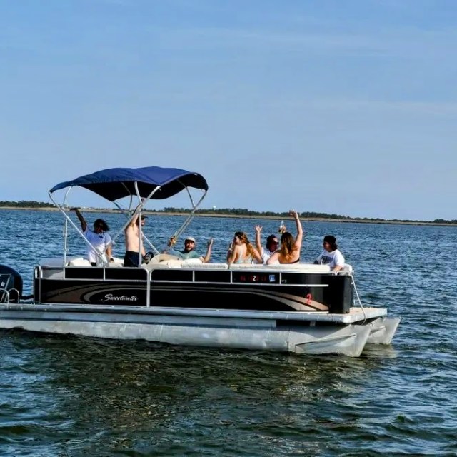 A group of friends having a great time on a pontoon boat rental while on their Outer Banks vacation.