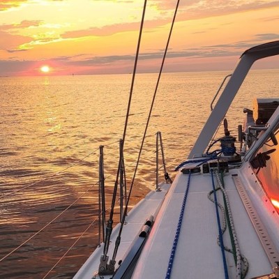a beautiful Outer Banks sunset, viewed on the side of Take Two sailing charters.