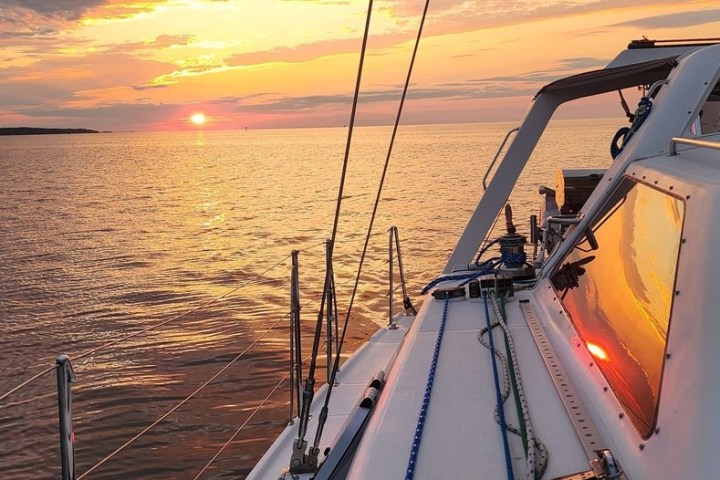 a beautiful Outer Banks sunset, viewed on the side of Take Two sailing charters.