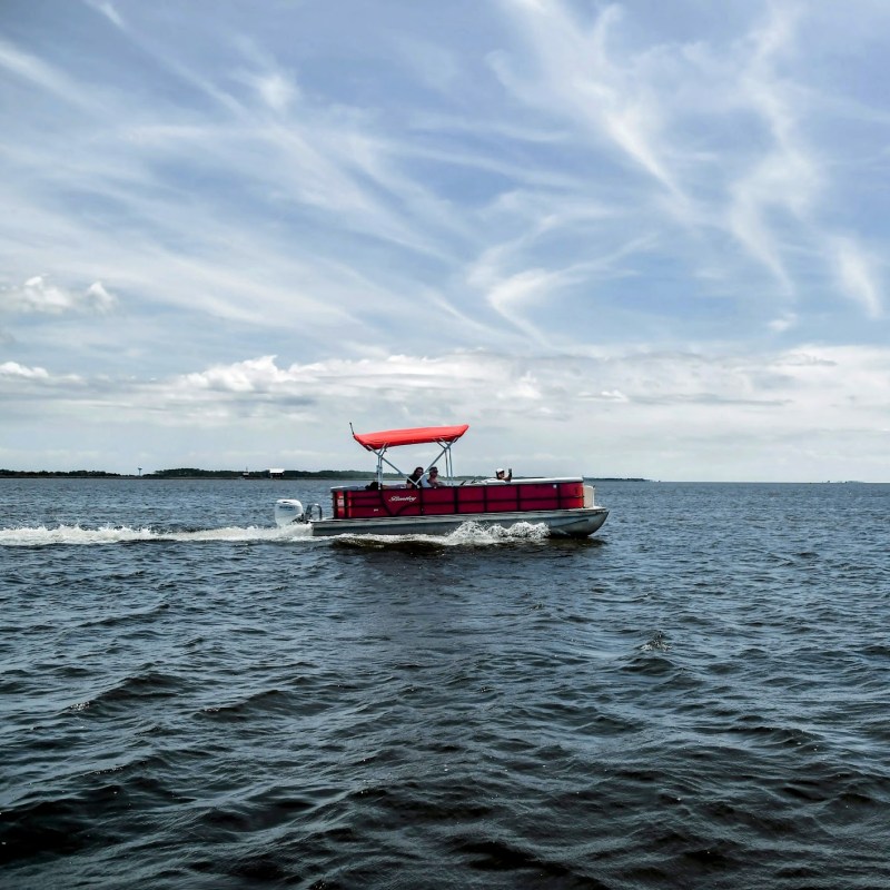 A group having a great time on a pontoon boat, cruising the waters of Nags Head.