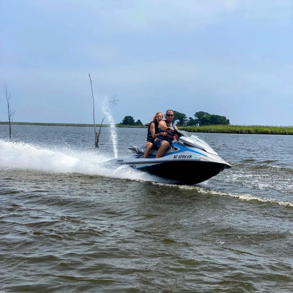 Friends riding on a jet ski together through the marsh lands of Wanchese, During their vacation at the Outer Banks NC.