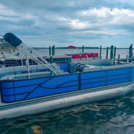 a blue and white boat sitting next to a body of water
